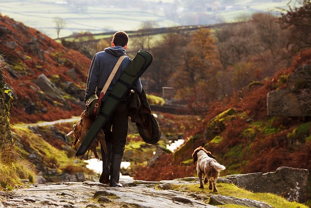 A man with a backpack and a dog walking down a trail in Ohio, possibly with a non resident hunting license