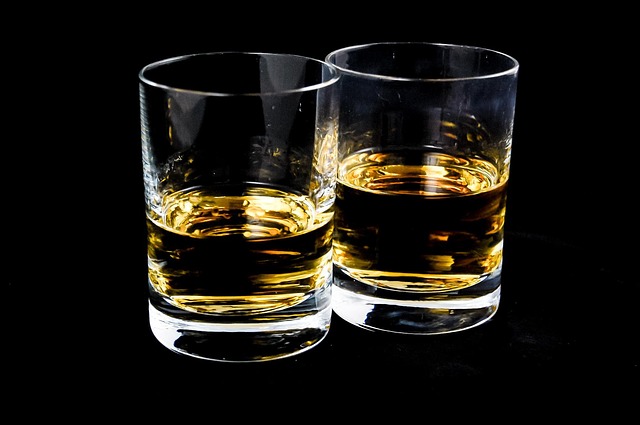 Two glasses of whiskey on black background