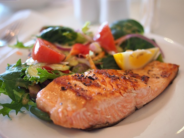 A plate of food featuring salmon and salad